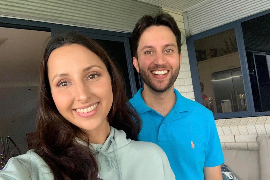 A young, dark-haired sister and brother, smiling for a selfie.