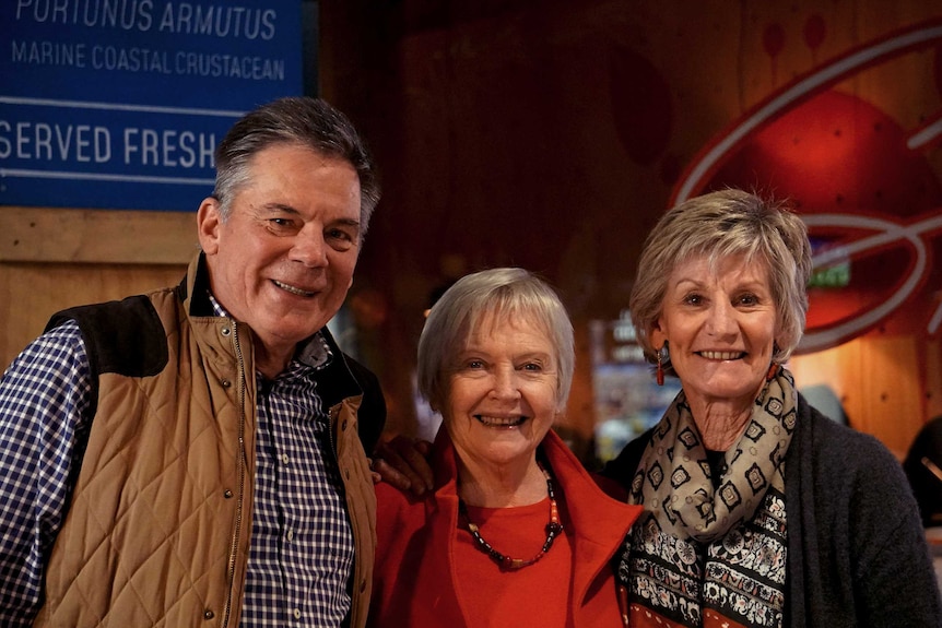 Three people, a man and two women, smile as they stand inside an Adelaide pop-up restaurant.