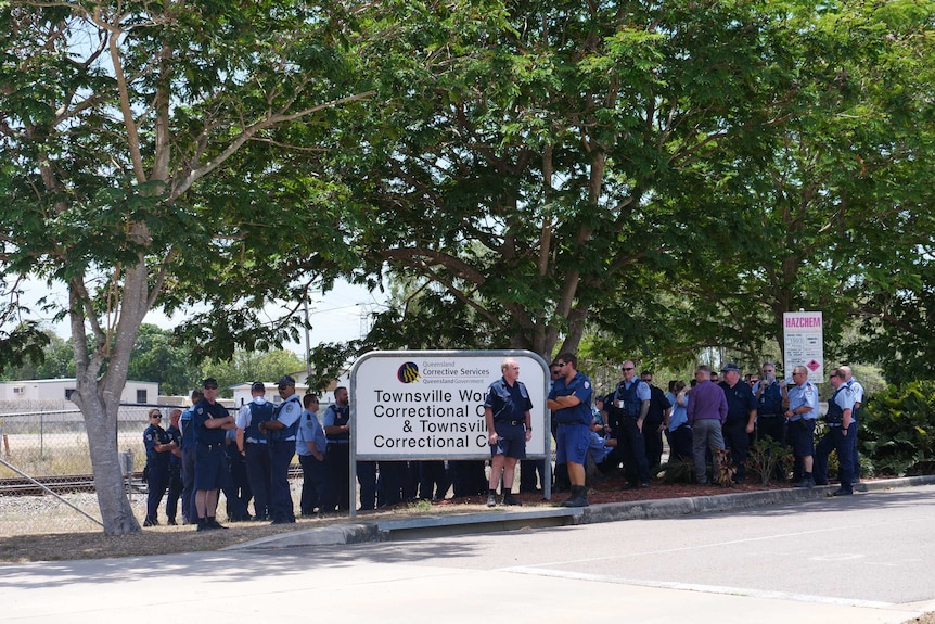 A group of prison officers stand outside Townsville Correctional Centre.