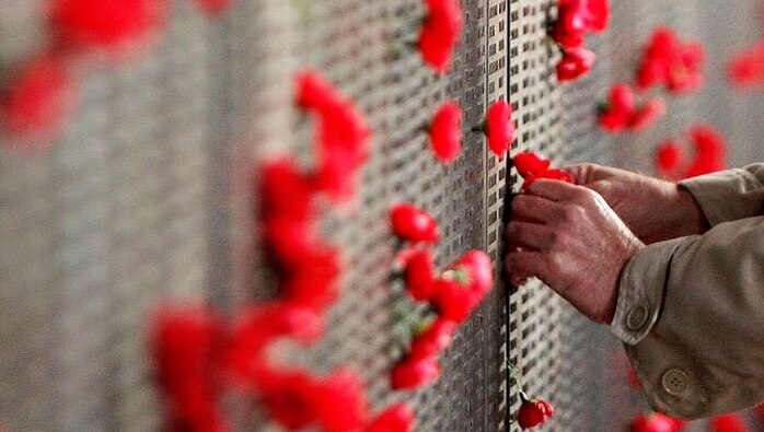 A man places a poppy on the Roll of Honour at the Australian War Memorial in Canberra (Getty Images: Mark Nolan)