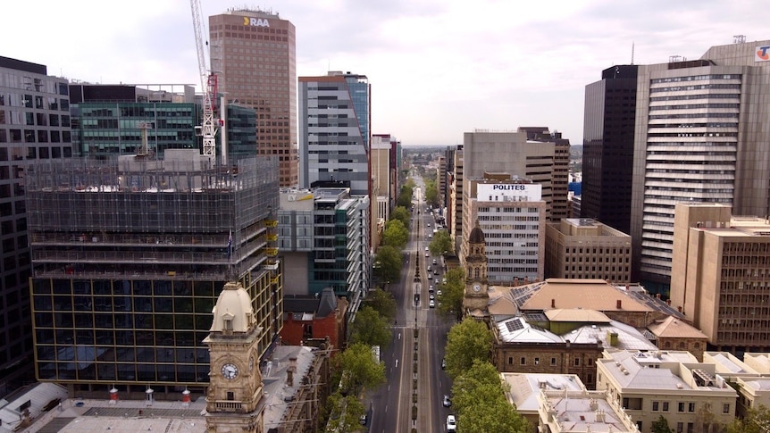 A drone shot of a city centre, with buildings lining a street.