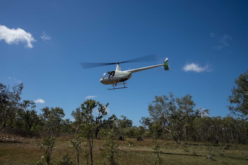 A helicopter takes off to start fires in Arnhem Land.