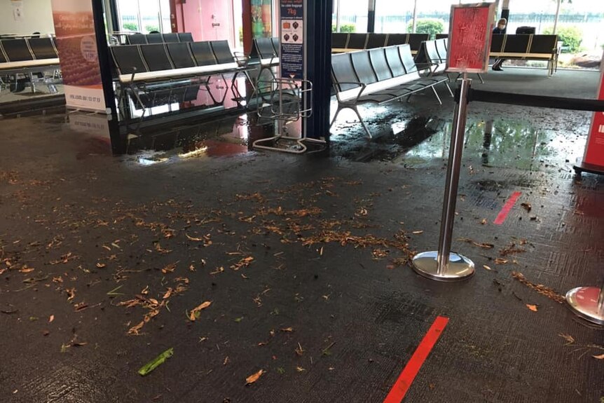 An image of an airport building with water and debris on the floor