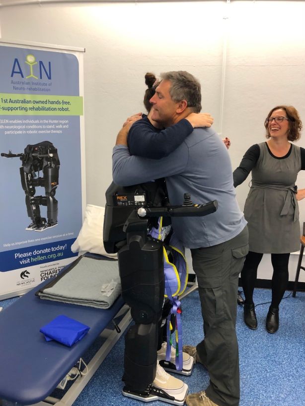 A man hugs a woman wearing a support device.