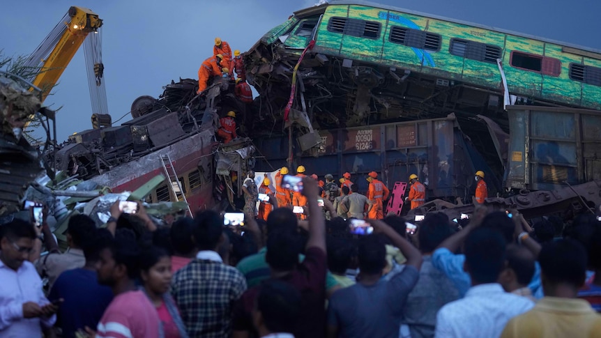 Rescuers work to take out the body of a victim of passenger trains that derailed in eastern India. 