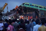 Rescuers work to take out the body of a victim of passenger trains that derailed in eastern India. 