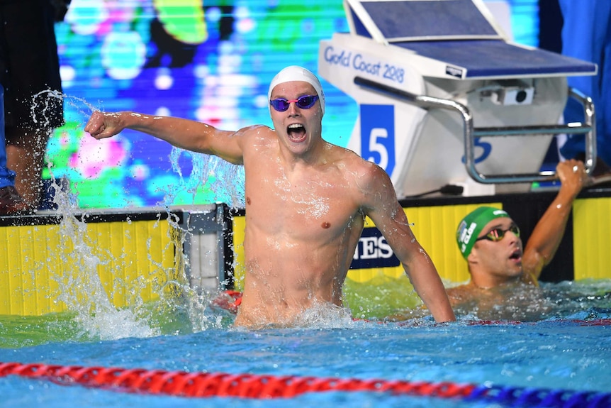 Scotland's Duncan Scott propels himself out of the water to celebrate winning the 100m freestyle