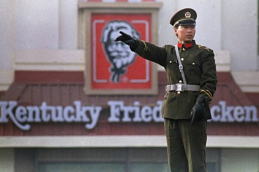 A Chinese traffic police officer working in front of China's first KFC restaurant at Qianmen area in Beijing.