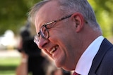 A side view of Anthony Albanese laughing.