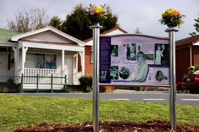 A plaque mounted on a chrome stand opposite the bus stop where Lucille Butterworth was last seen.