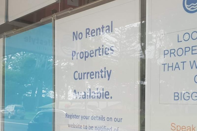 A sign in the window of a real estate agency says  there are no permanent rentals available.
