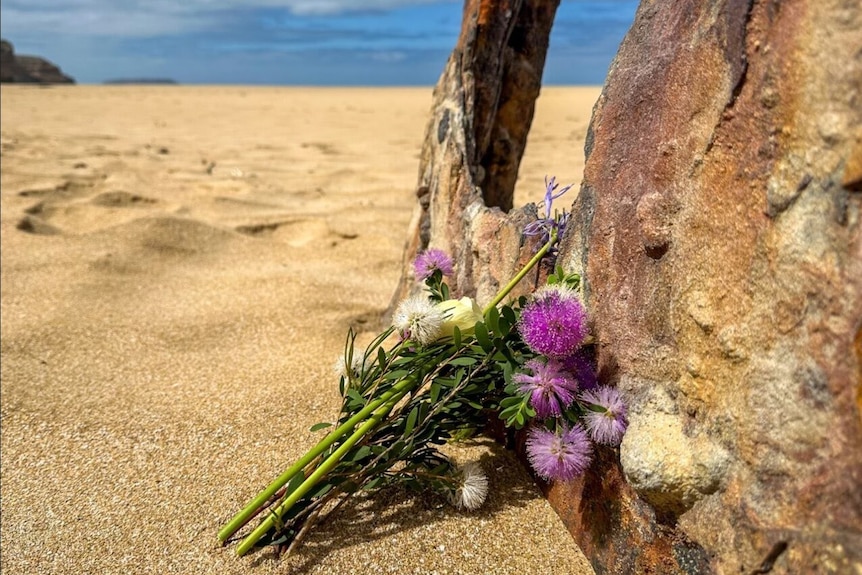 A small bunch of flowers left in tribute to a shark attack victim.