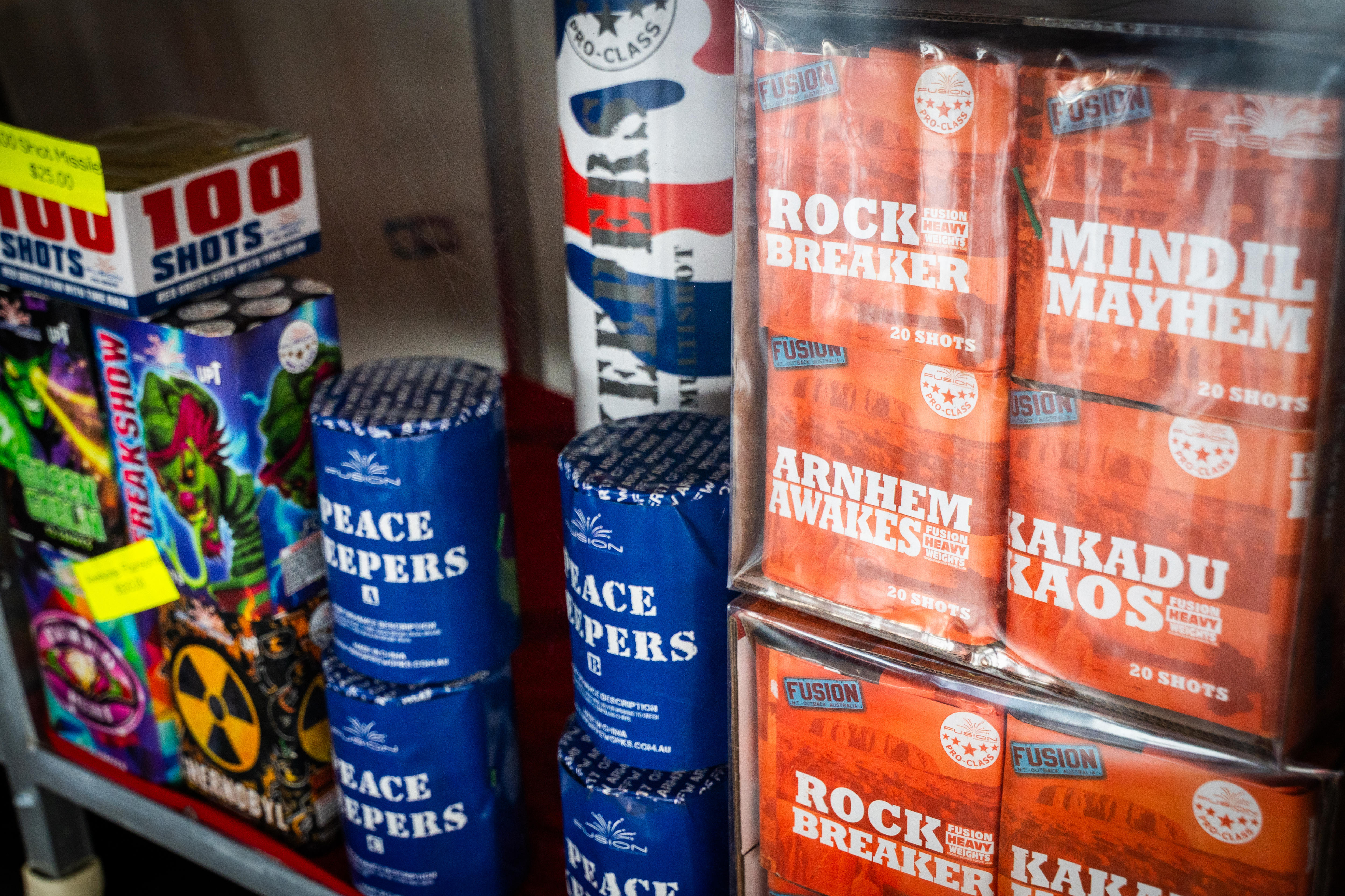 An array of brightly coloured boxes, all holding fireworks, arranged on a store shelf.