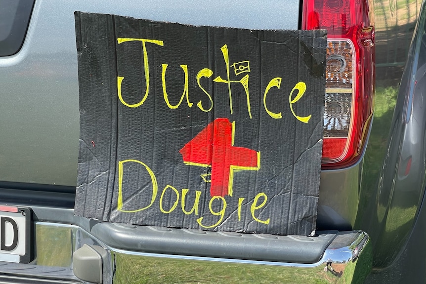  A black sign says justice for Dougie