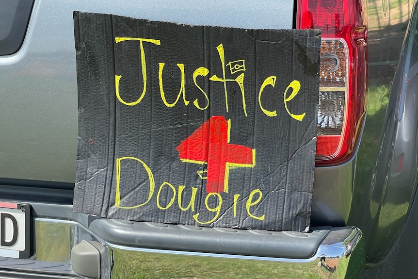  A black sign says justice for Dougie.