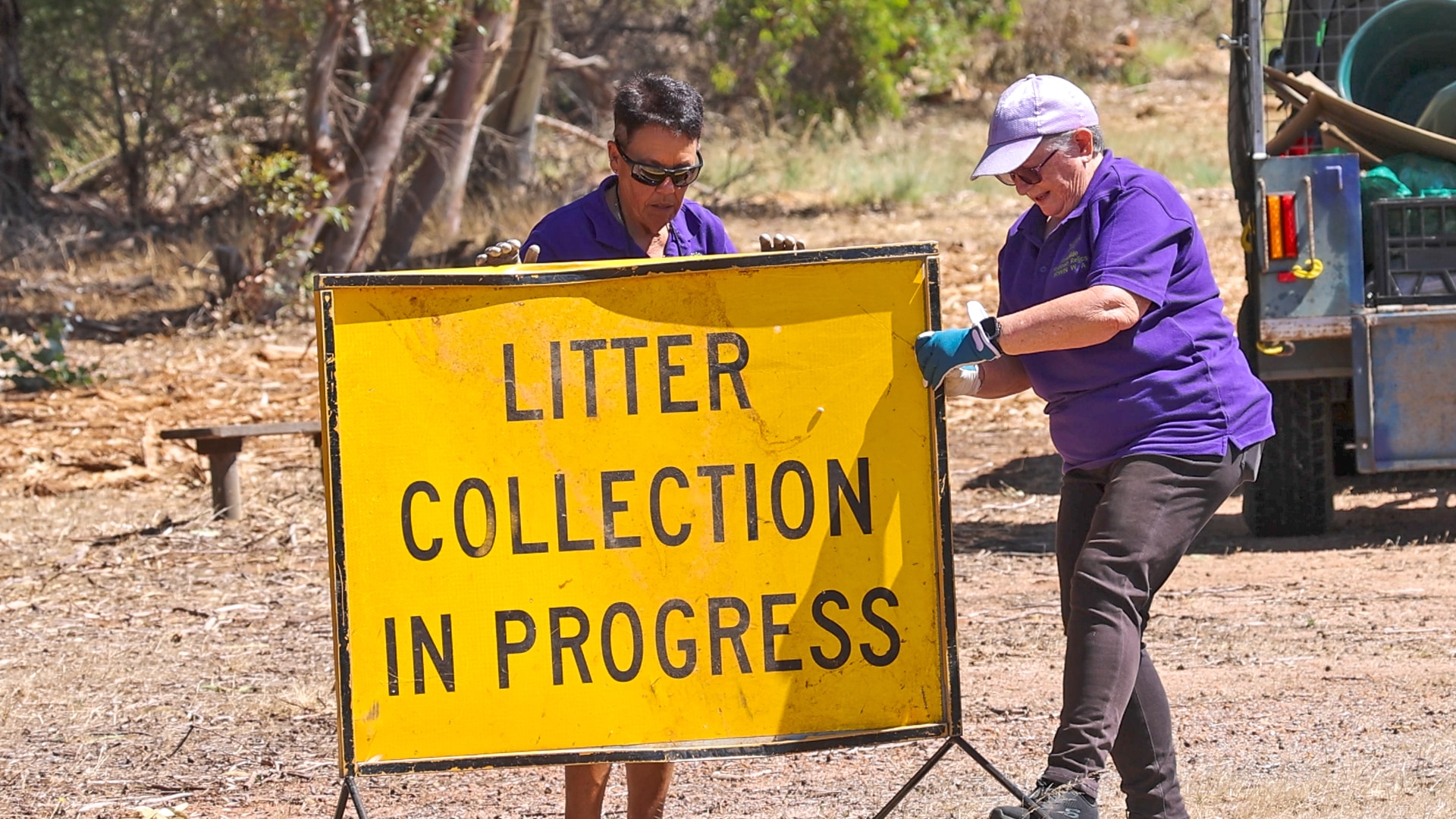 Sherry Martin e Glenda Green colocaram um "coleta de lixo em andamento" inscreva-se na beira de uma estrada.