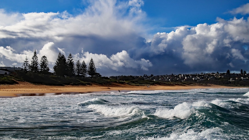 A photo of a beach as storm clouds roll in from the horizon
