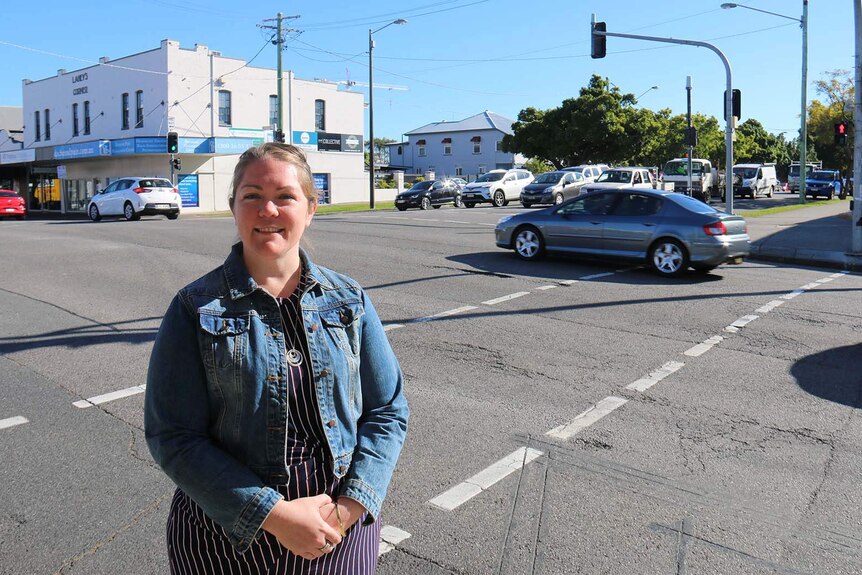 Amy Miller stands at an intersection in a busy suburban area in East Brisbane.