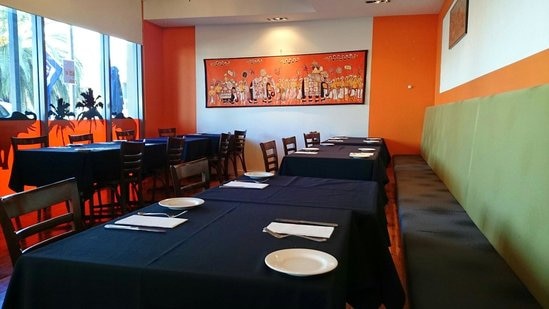 A restaurant with empty tables and orange and blue decor
