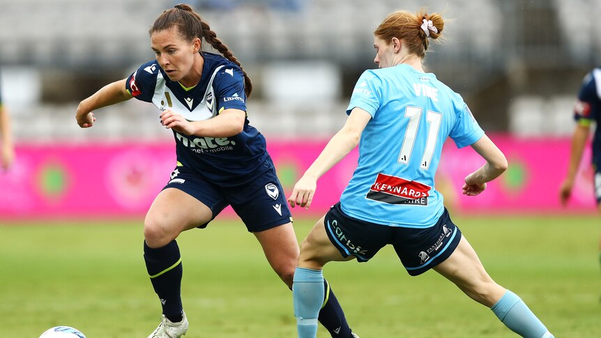 A Melbourne Victory A-League Women player tries to get past a Sydney FC opponent in the grand final.