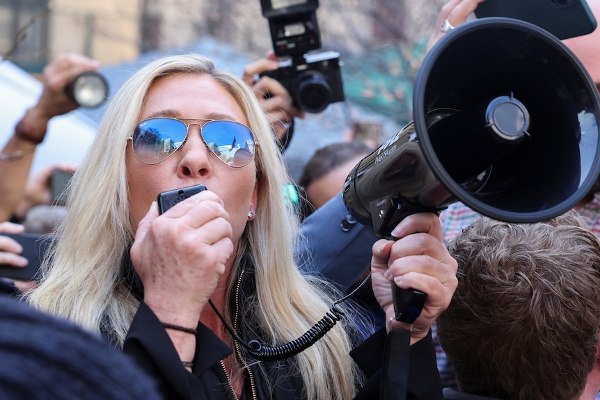 A woman speaks into a megaphone