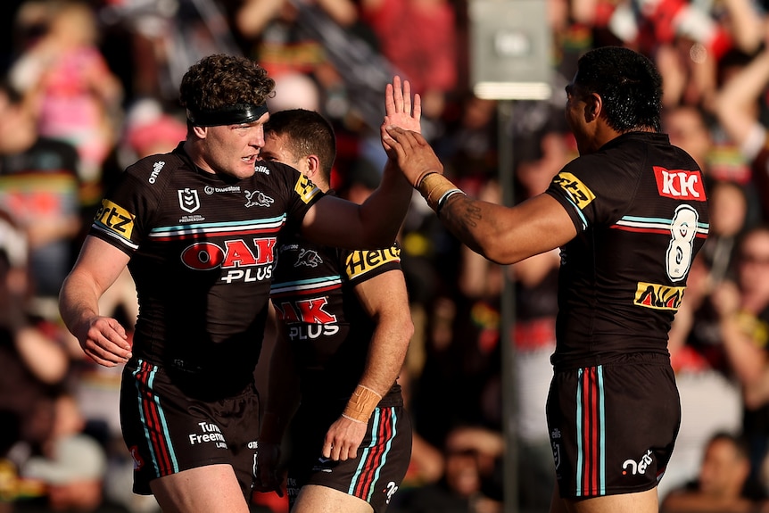 Two men celebrate after scoring a try in an NRL final