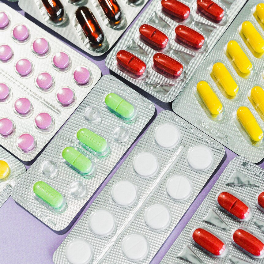 A collection of different coloured pills in their packaging 