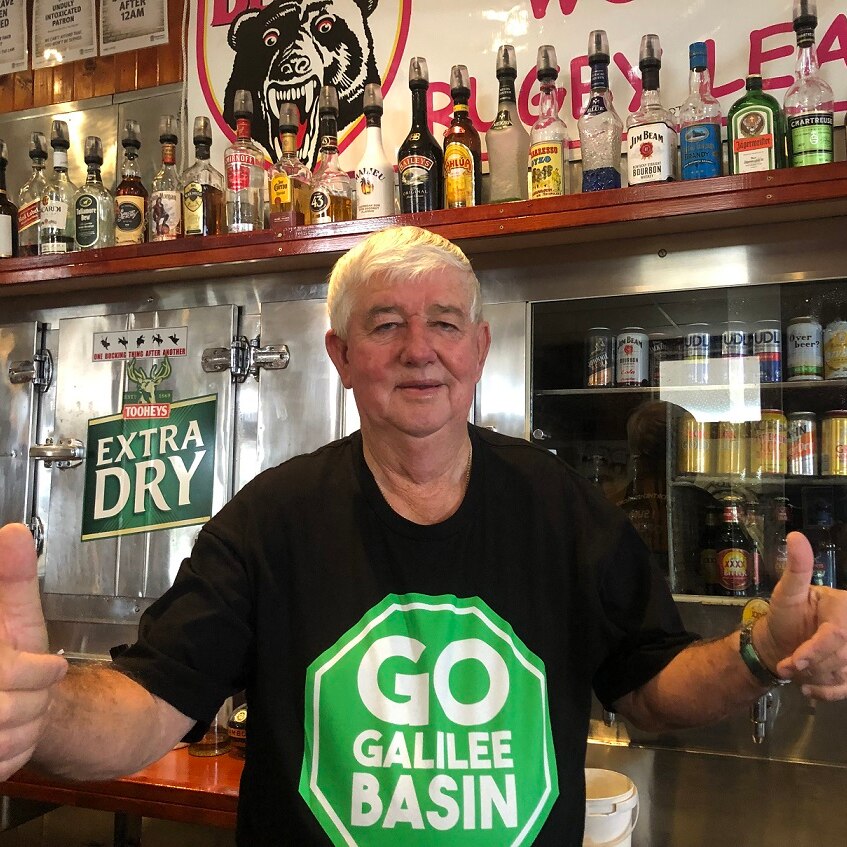 Pub owner Leslie Boal in Clermont wears a pro-Adani shirt and gives the thumbs up.