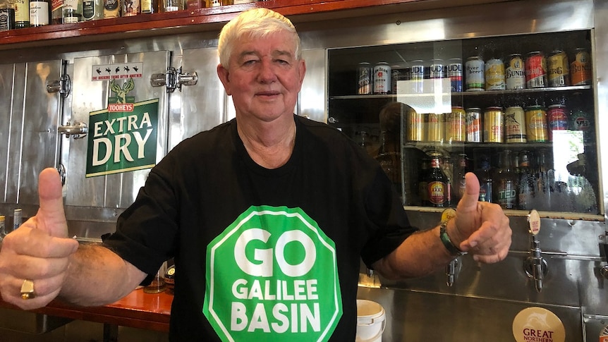 Pub owner Leslie Boal in Clermont wears a pro-Adani shirt and gives the thumbs up.