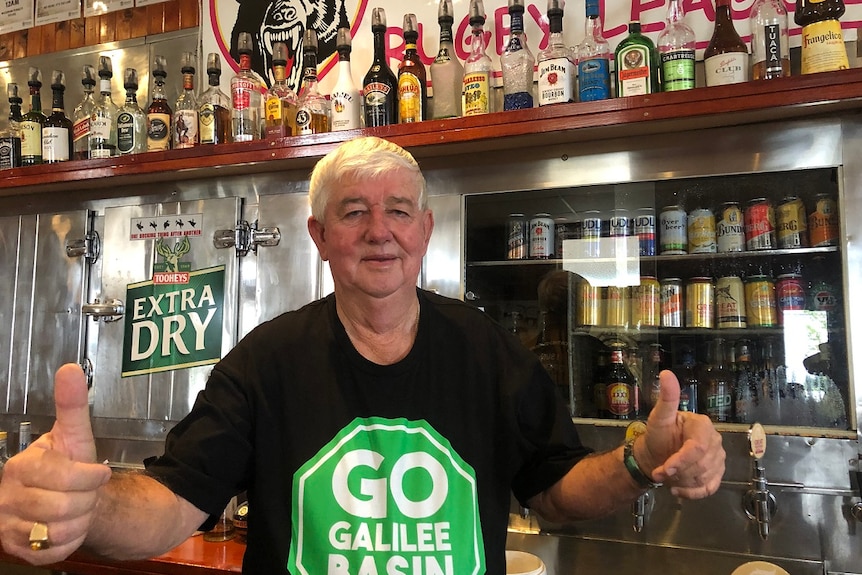 Pub owner Leslie Boal in Clermont wears a pro-Adani shirt and gives the thumbs up.