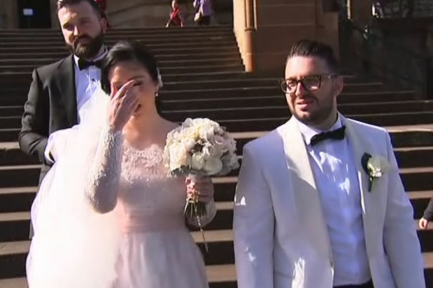 A bride and groom walk down steps.