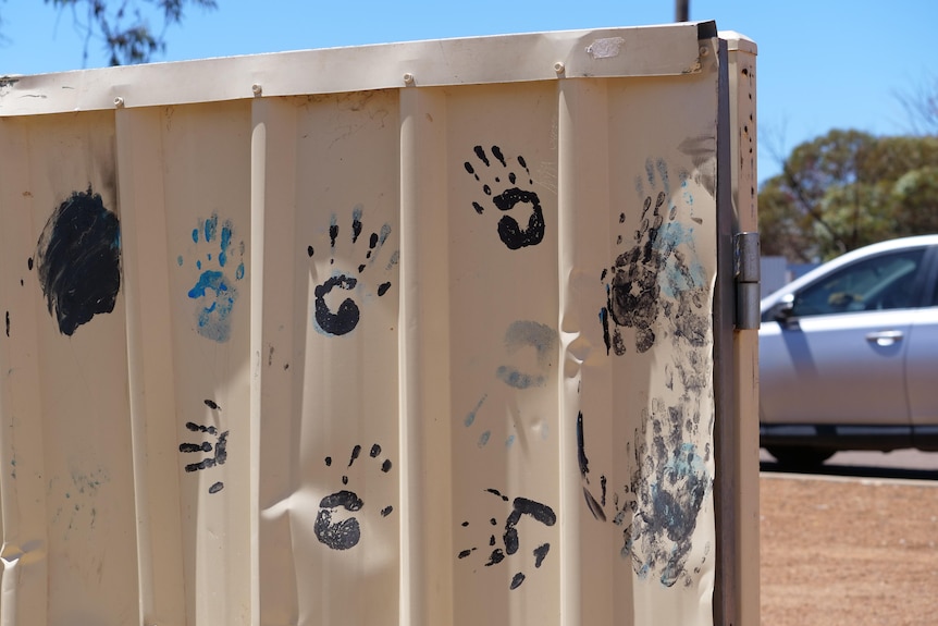 Paint handprints on a fence.