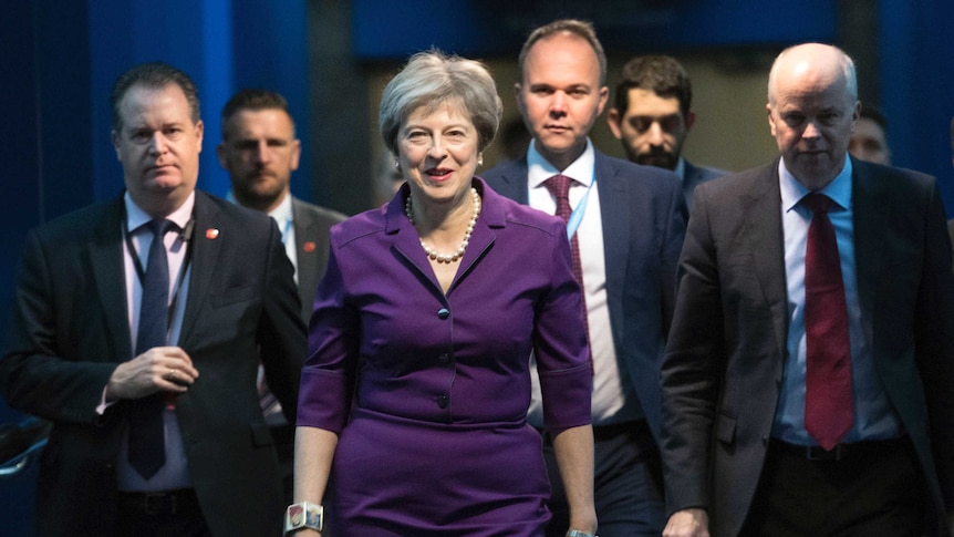 Theresa May wears a purple suit as she walks into the Conservative conference
