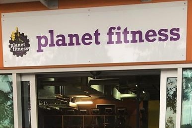 A sign saying planet fitness over an open door.