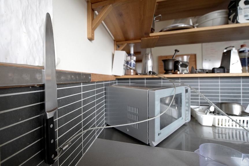 A kitchen with a knife tied to a bench.