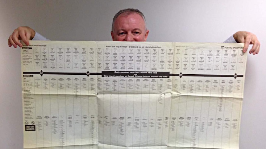 ABC election analyst Antony Green holds a ballot paper