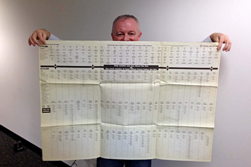 ABC election analyst Antony Green holds a ballot paper