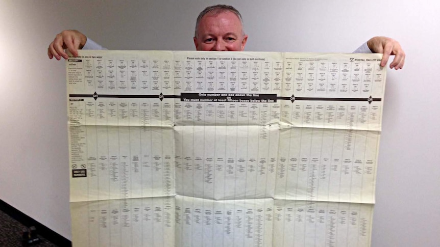 ABC election analyst Antony Green holds a ballot paper