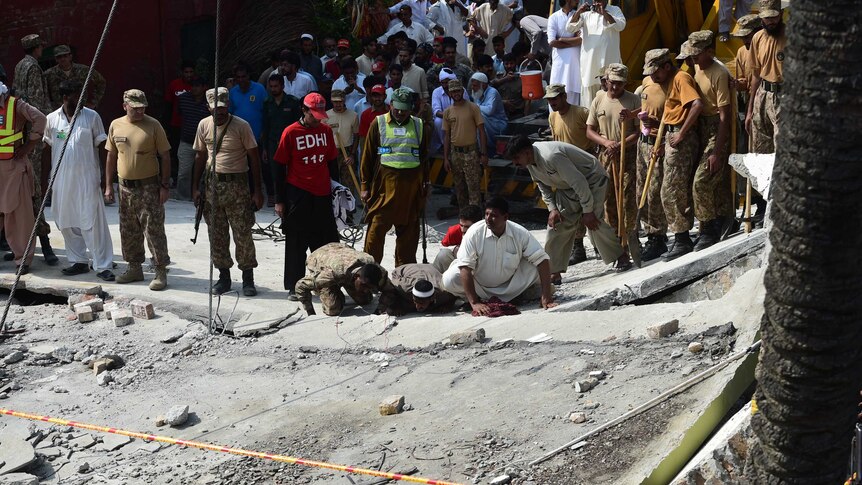 Pakistan's army and rescuers search for survivors in the wreckage of the collapsed building at the bomb site.