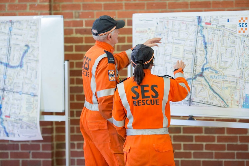 Victorian SES volunteers looking at a map of Melbourne. 