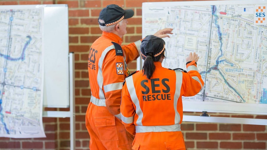 Victorian SES volunteers looking at a map of Melbourne. 