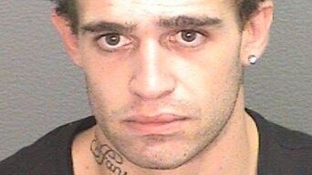 A mugshot of a young man with a tattoo on his neck