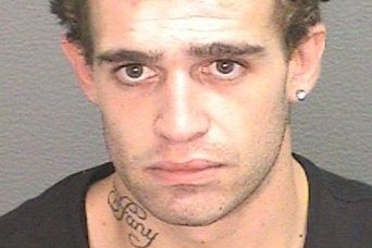A mugshot of a young man with a tattoo on his neck