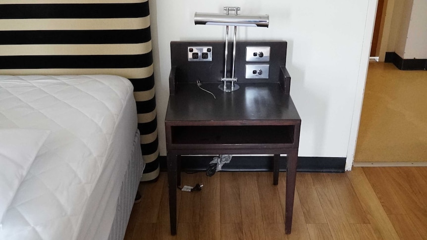 A bedside table next to a bed