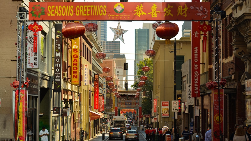 A wide shot of a street in chinatown with lanterns and banners celebrating the new year