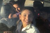 The Ibrahim children smile happily on their journey home.