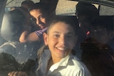 The Ibrahim children smile happily on their journey home.