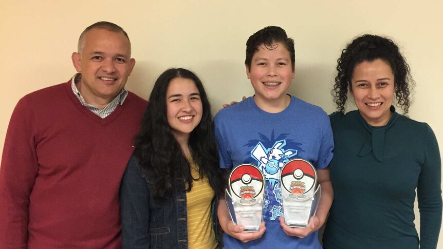 Alfredo holds his trophies, flanked by his father, sister and mother.