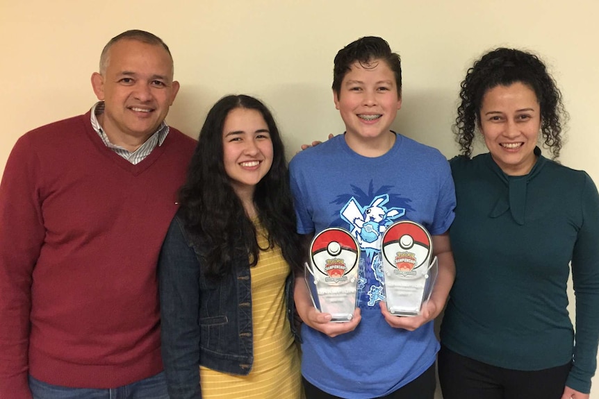 Alfredo holds his trophies, flanked by his father, sister and mother.