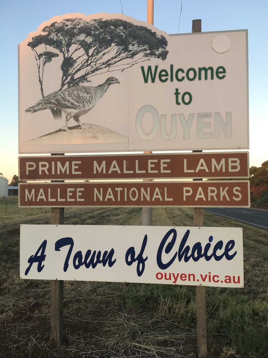 A sign reads: "Welcome to Ouyen, Prime Mallee Lamb, Mallee National Park, A Town of Choice", while displaying a Malleefowl.